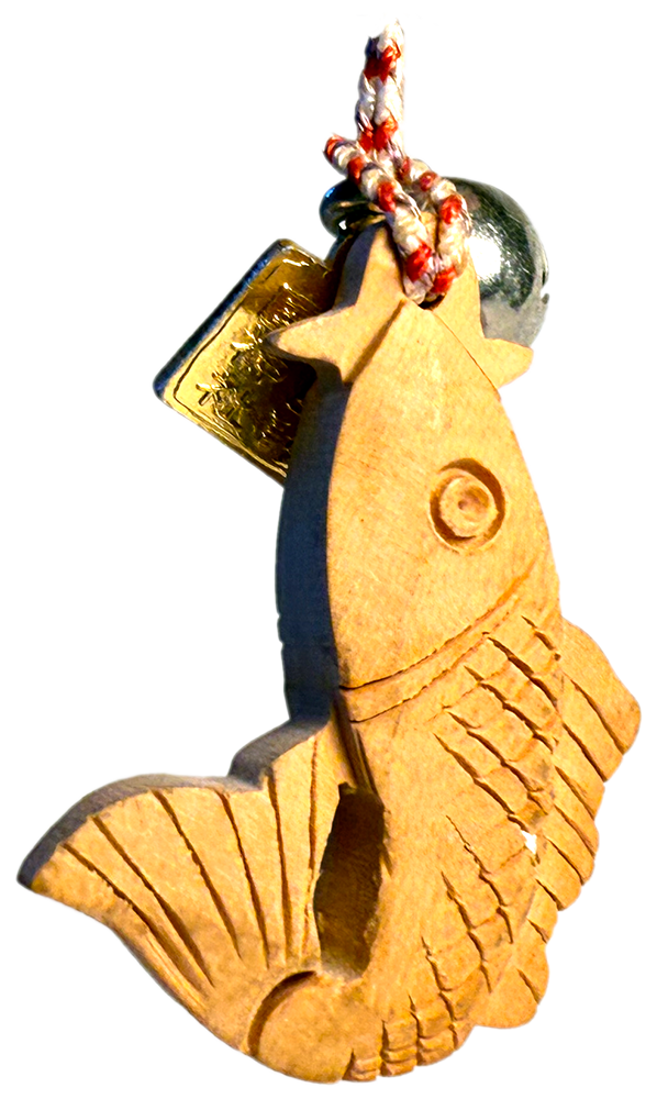 small wooden charm in the shape of a fish