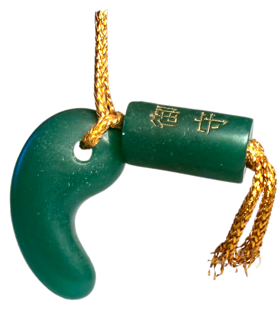 small jade charm with Japanese writing carved in it